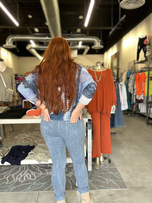 Person wearing a blue denim outfit in a clothing store.