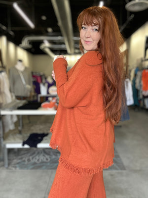 Woman wearing an orange outfit in a clothing store